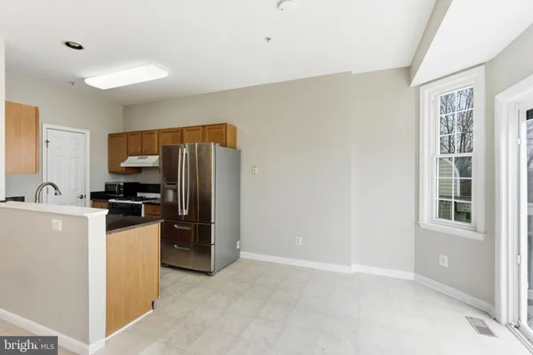 a kitchen with granite countertop a refrigerator and a stove top oven