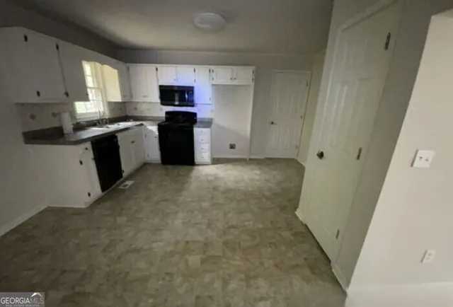 a kitchen with granite countertop white cabinets and stainless steel appliances