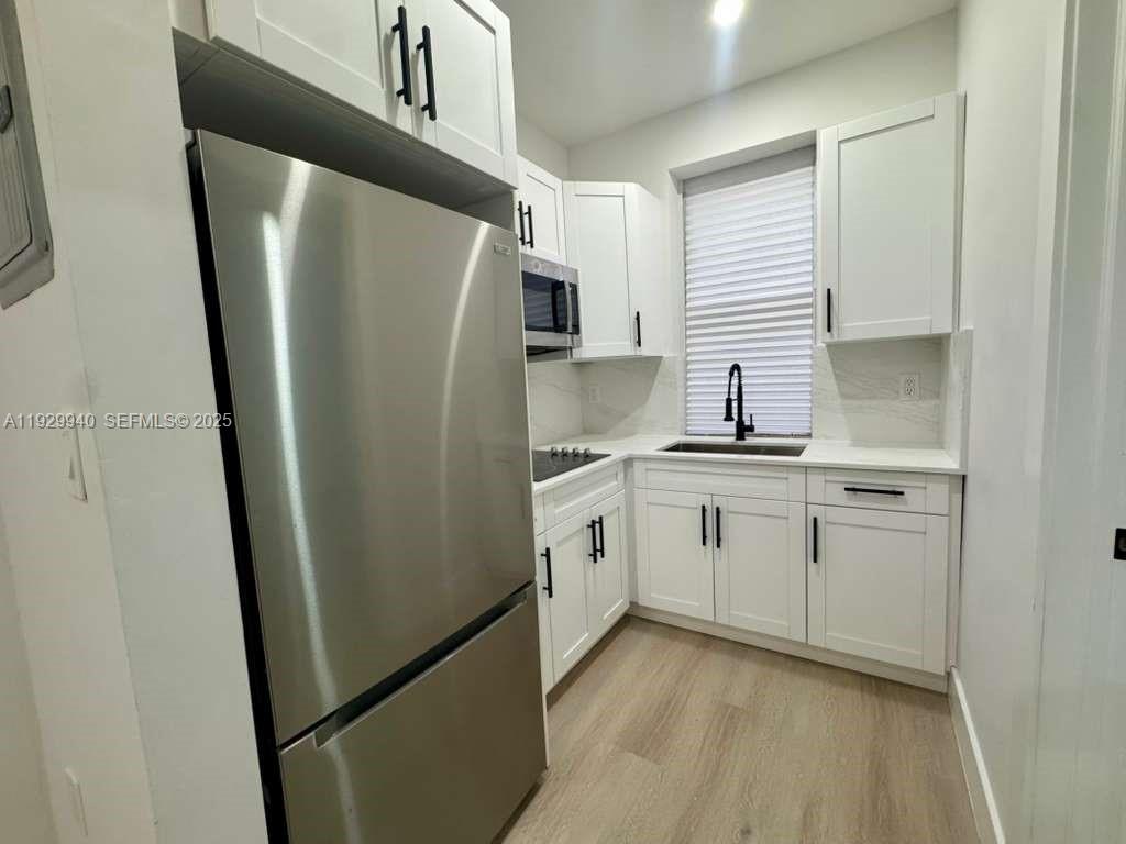 2425 Southwest 6th Street, Unit 12 Miami, FL 33135 - Photo 1 of 13 a kitchen with a refrigerator sink and cabinets