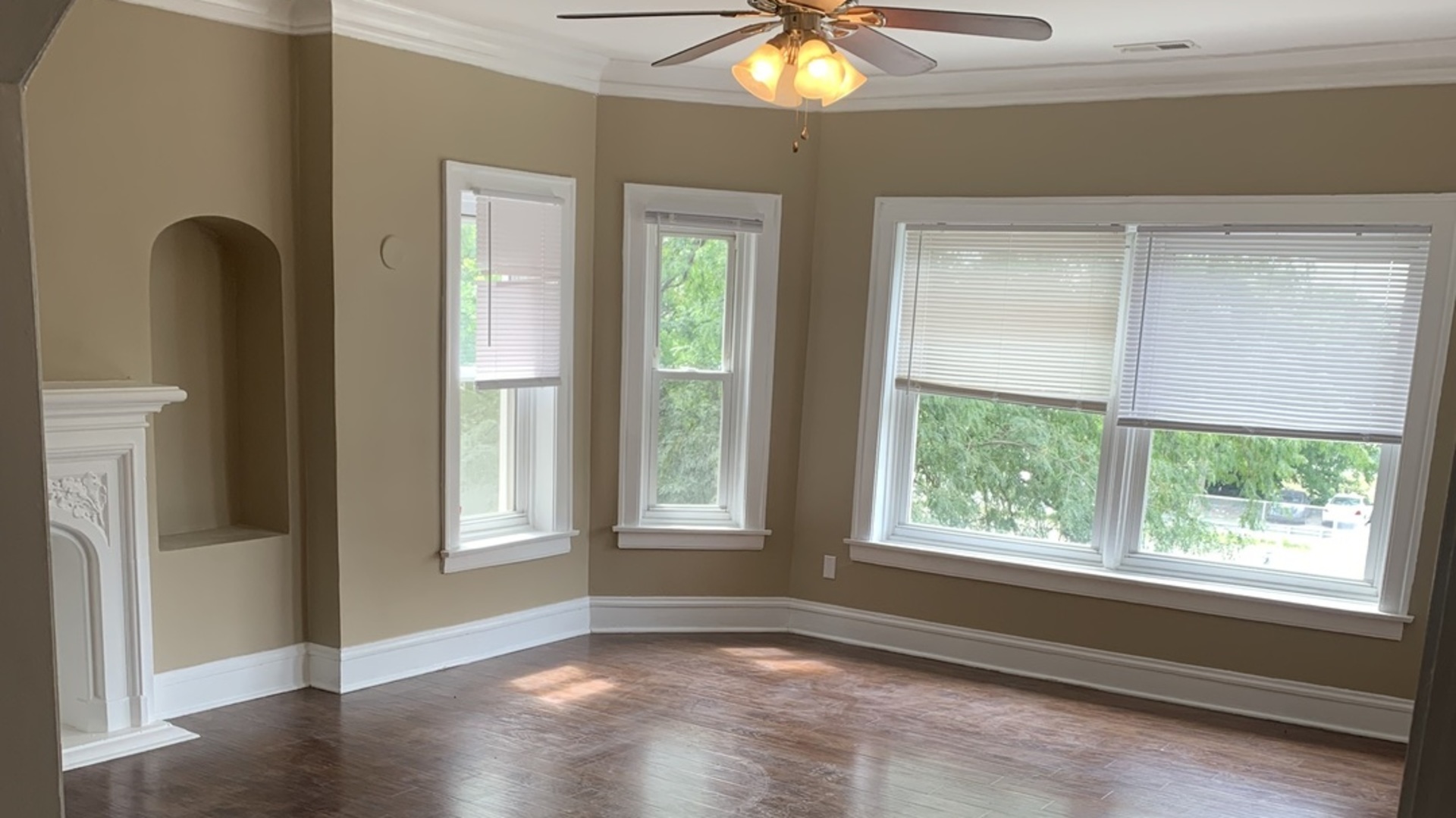 7831 South Cornell Avenue, Unit 3 Chicago, IL 60649 - Photo 1 of 11 a view of an empty room with wooden floor and a window