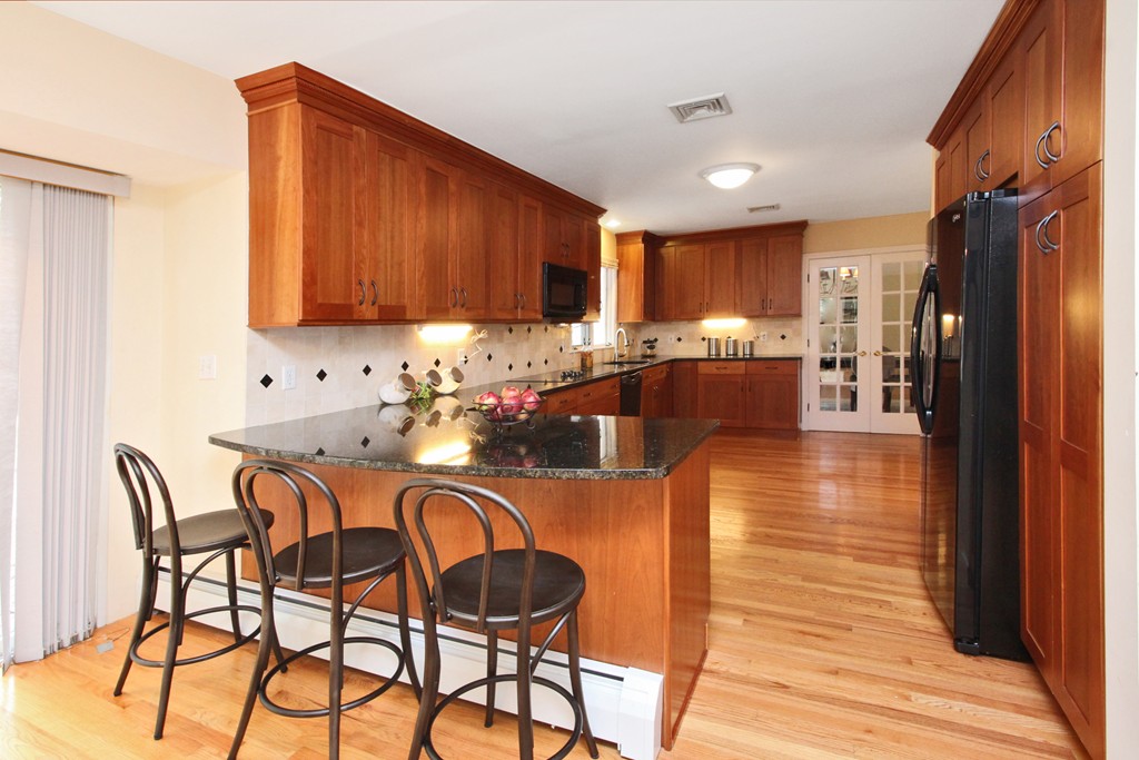 83 Spring Valley Road Belmont, MA 02478 - Photo 12 of 30 a kitchen with granite countertop a table chairs microwave and refrigerator