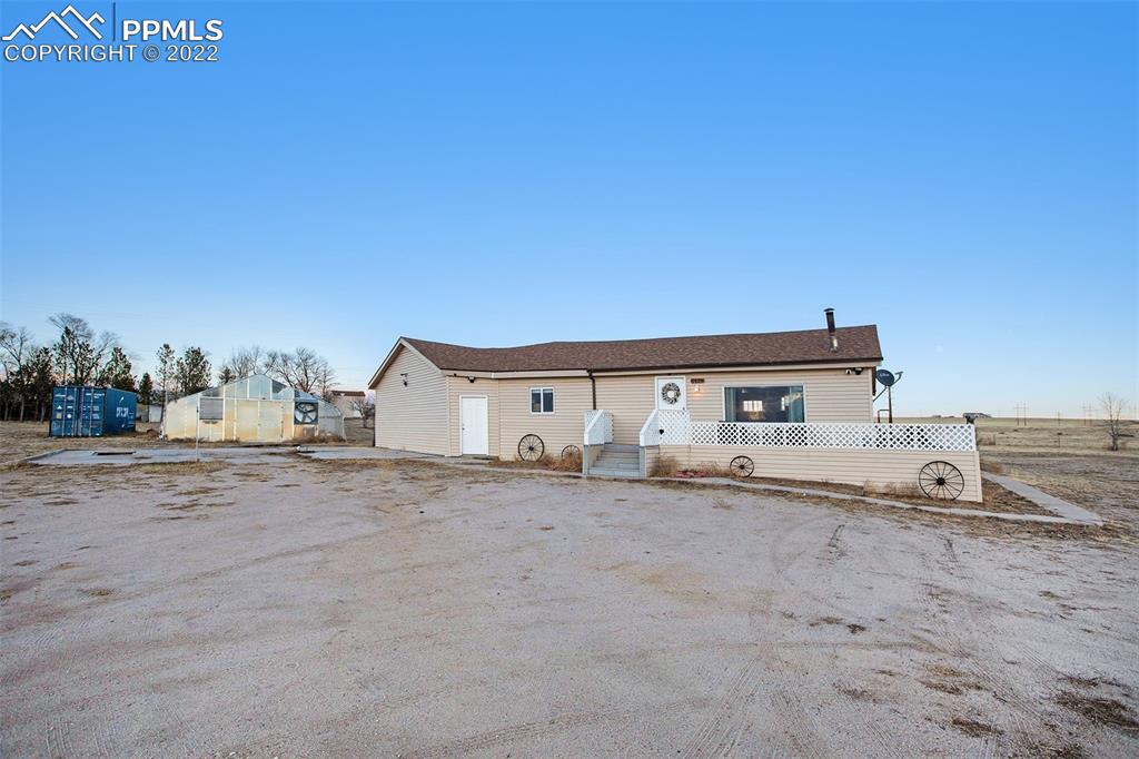 1495 North Yoder Road Yoder, CO 80864 - Photo 15 of 25 a view of a house with a big yard and large tree