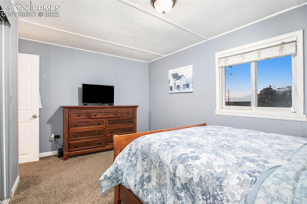 1495 North Yoder Road Yoder, CO 80864 - Photo 24 of 25 a bedroom with a bed and a flat screen tv