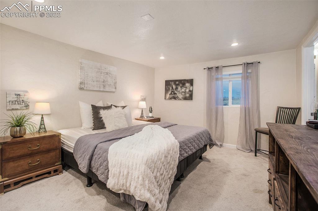 1495 North Yoder Road Yoder, CO 80864 - Photo 7 of 25 a spacious bedroom with a bed and a lamp on table
