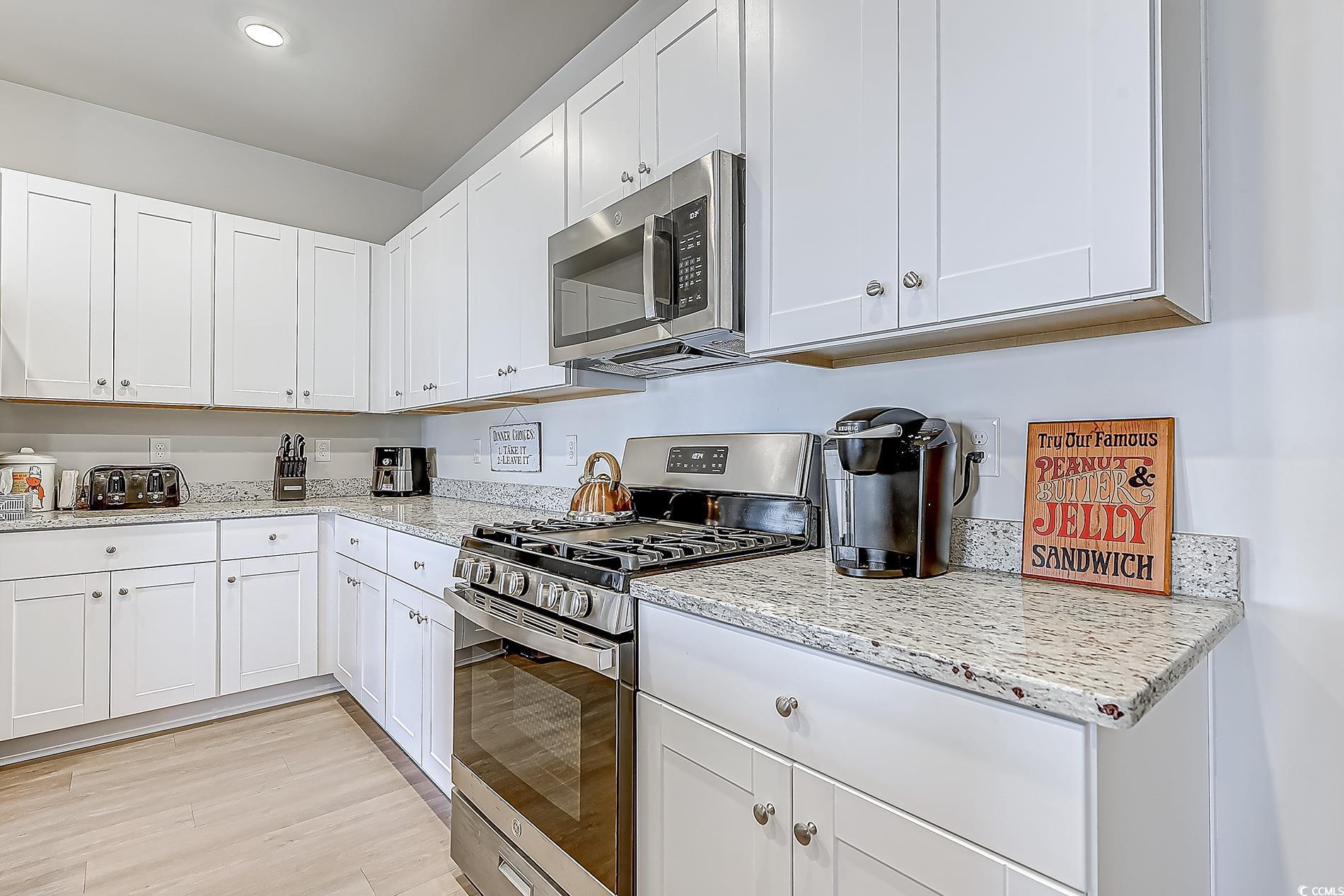 177 Fox Rae Drive Conway, SC 29526 - Photo 6 of 39 Kitchen featuring appliances with stainless steel finishes, white cabinetry, and light stone counters