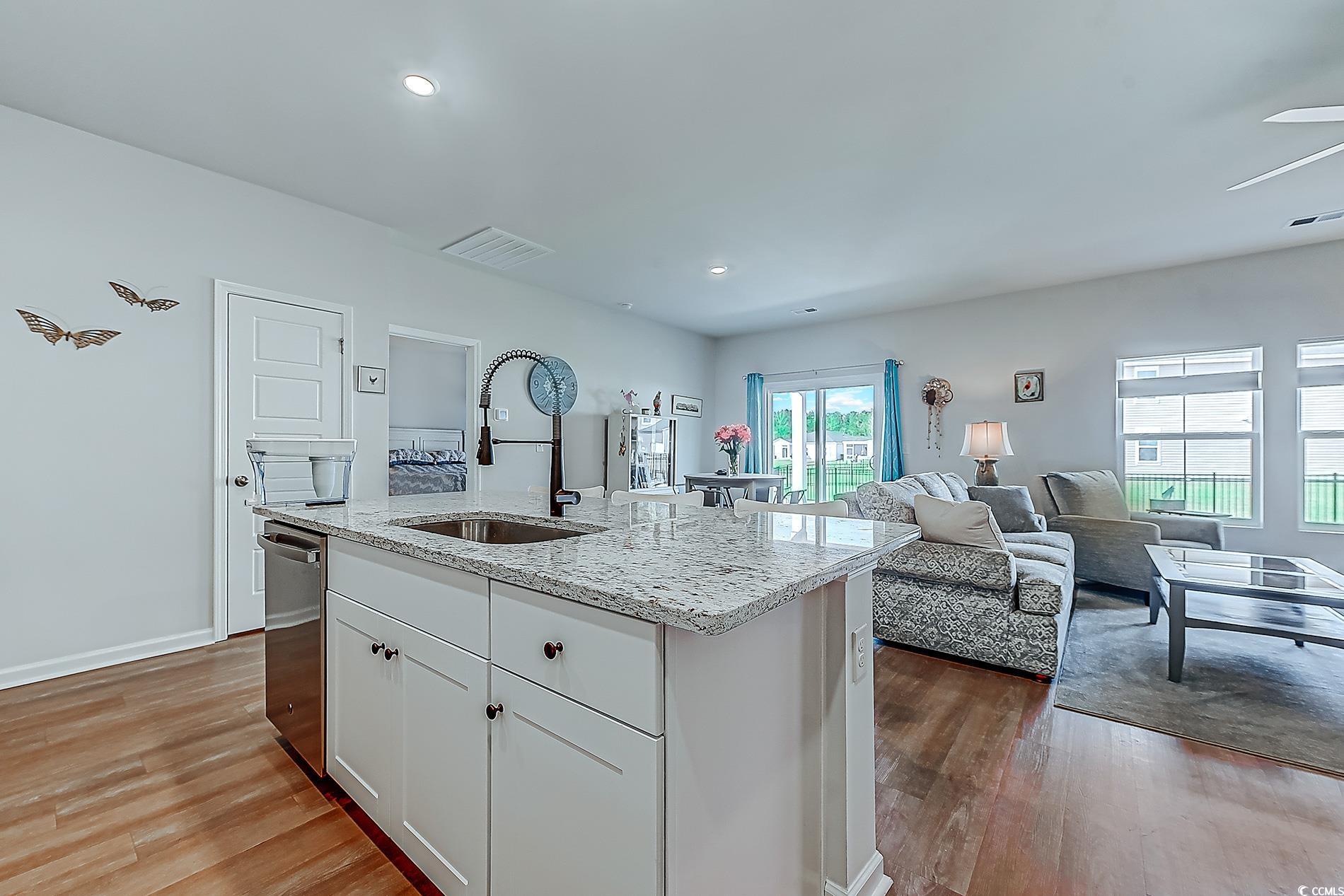 177 Fox Rae Drive Conway, SC 29526 - Photo 7 of 39 Kitchen featuring white cabinetry, light stone countertops, light wood-style floors, a center island with sink, and recessed lighting