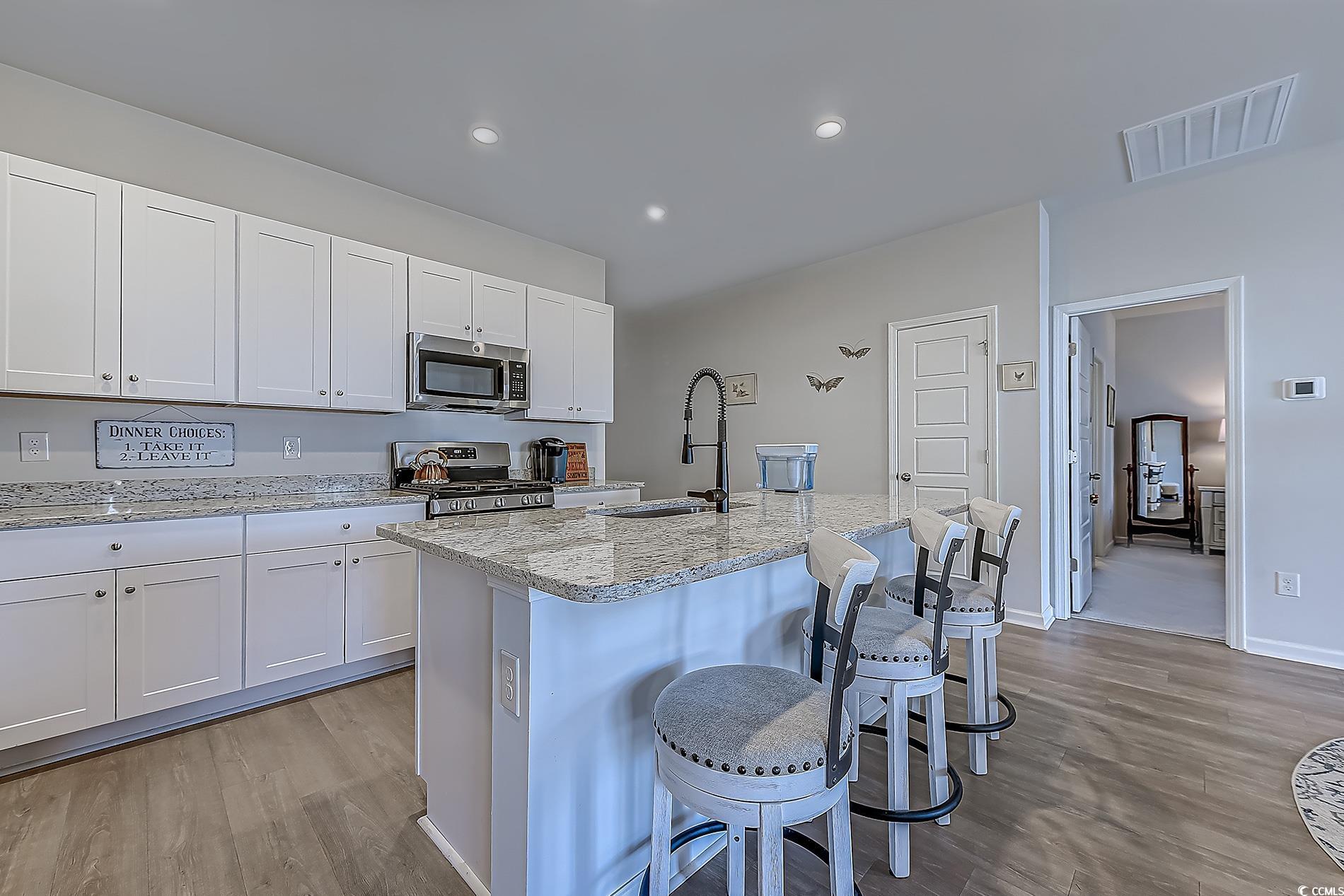 177 Fox Rae Drive Conway, SC 29526 - Photo 9 of 39 Kitchen with a breakfast bar, light wood-style floors, white cabinets, and recessed lighting