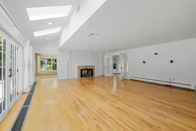 a view of empty room with wooden floor and fireplace