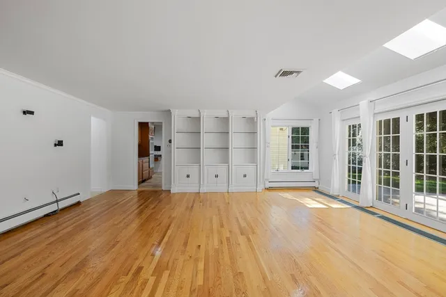 a big room with wooden floor and windows