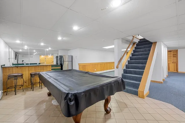 a room with furniture pool table and flat screen tv