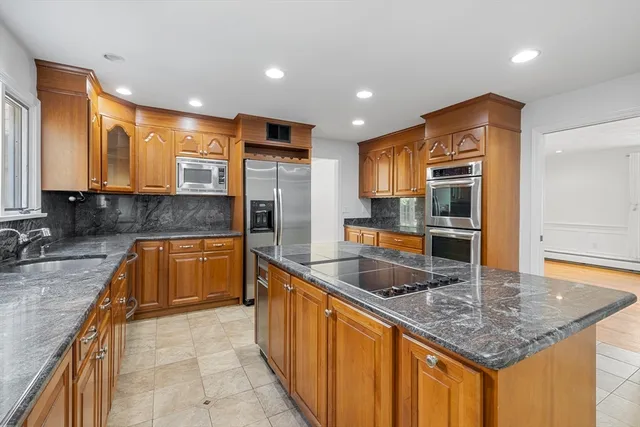 a kitchen with stainless steel appliances granite countertop a sink a stove and a refrigerator