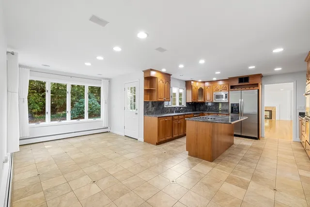 a large kitchen with stainless steel appliances granite countertop a large counter top and a view of kitchen