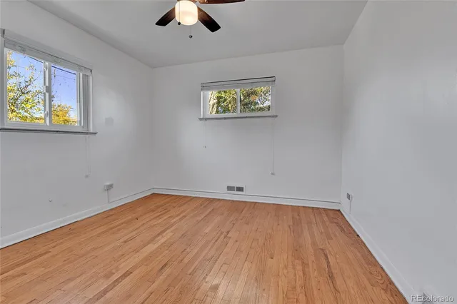 an empty room with a window and wooden floor