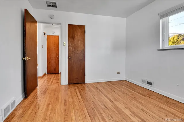 a view of a room with wooden floor and a window