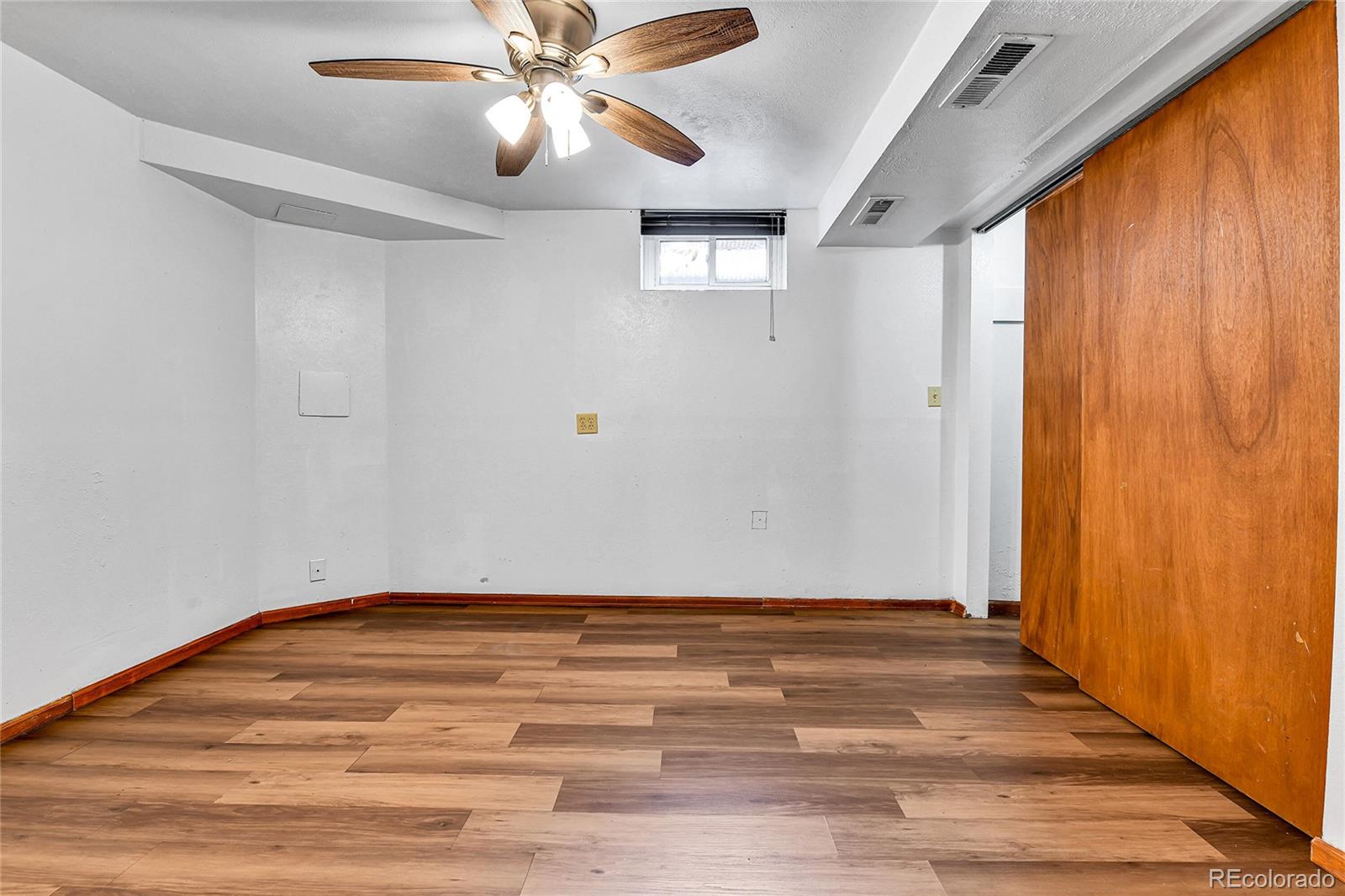 3591 Pontiac Street Denver, CO 80207 - Photo 19 of 26 a view of an empty room with wooden floor and a window
