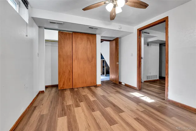 a view of a livingroom with wooden floor and an entryway