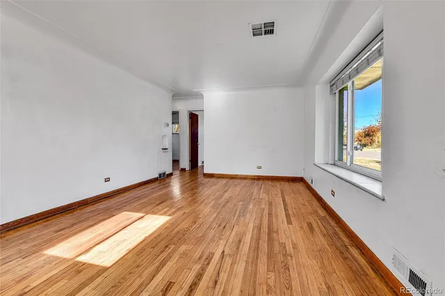 a view of a room with wooden floor and window