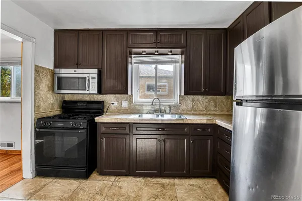 a kitchen with a sink stove and refrigerator