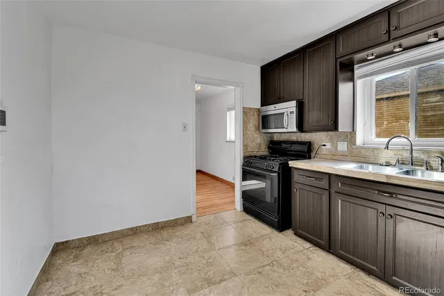 a kitchen with granite countertop a stove top oven and sink