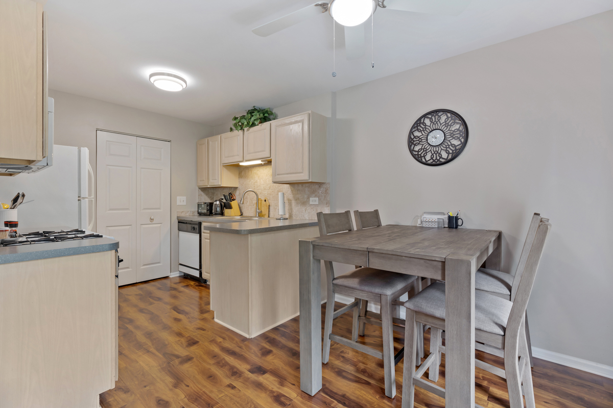 320 Crestview Drive, Unit B Wauconda, IL 60084 - Photo 15 of 28 a kitchen with granite countertop a table chairs stove and cabinets