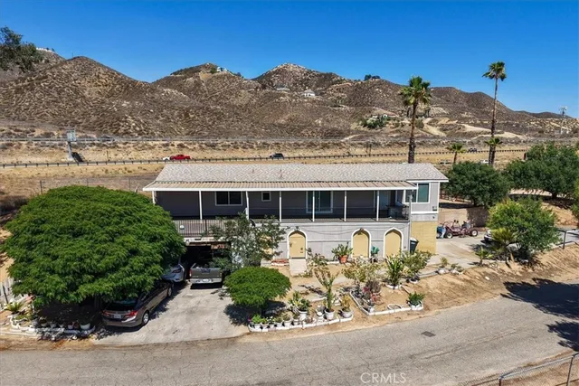 a front view of a house with a yard and mountain view