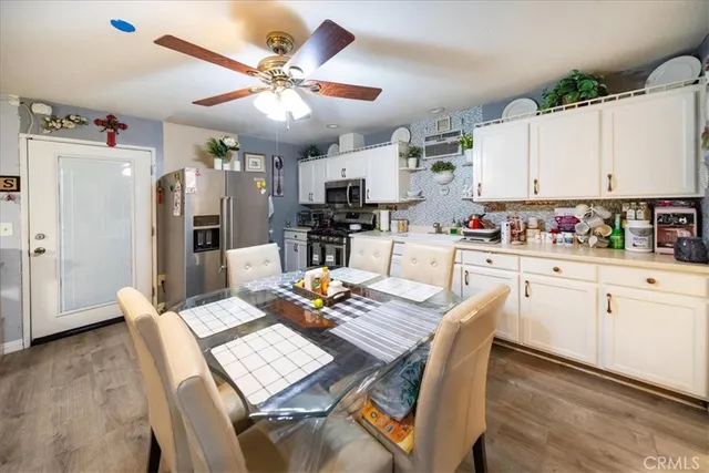 a kitchen with stainless steel appliances kitchen island granite countertop a table chairs and a refrigerator