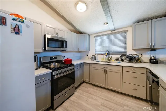 a kitchen with granite countertop a sink cabinets and stainless steel appliances