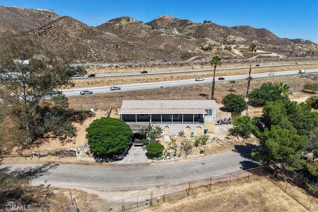 an aerial view of a house with a yard and mountain view in back