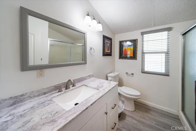 a bathroom with a sink vanity granite and toilet
