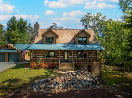 a kitchen with stainless steel appliances kitchen island granite countertop a table chairs and a refrigerator