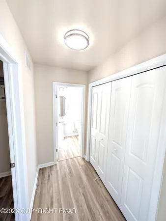 a view of a hallway with wooden floor and staircase