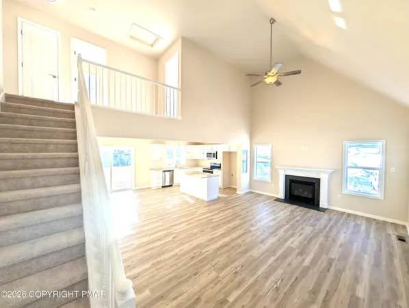 a large kitchen with kitchen island a large counter top space a sink stainless steel appliances and cabinets