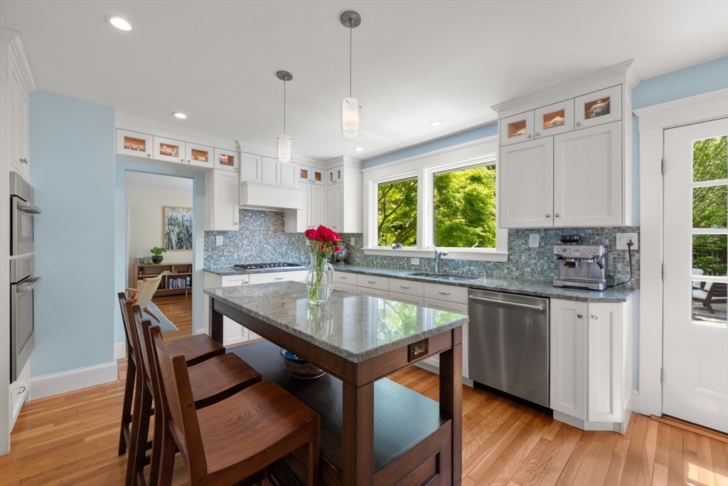 8 Charlotte Road Marblehead, MA 01945 - Photo 13 of 37 a kitchen with stainless steel appliances granite countertop a stove a sink a microwave a dining table and chairs