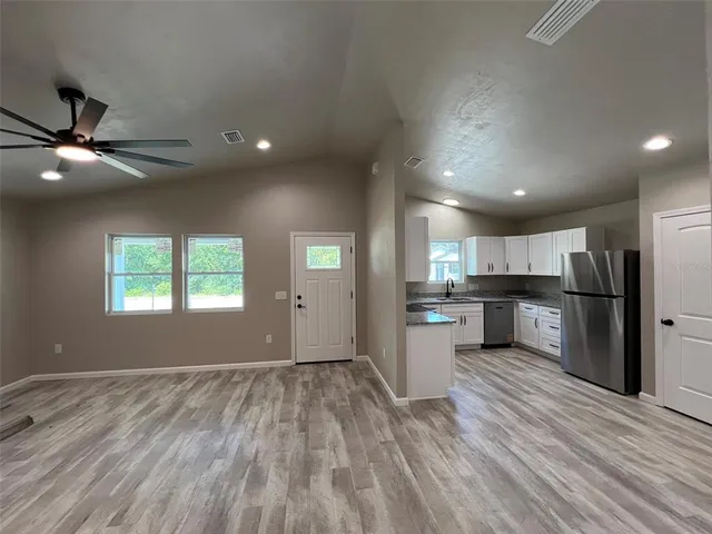a view of kitchen with wooden floor electronic appliances and window