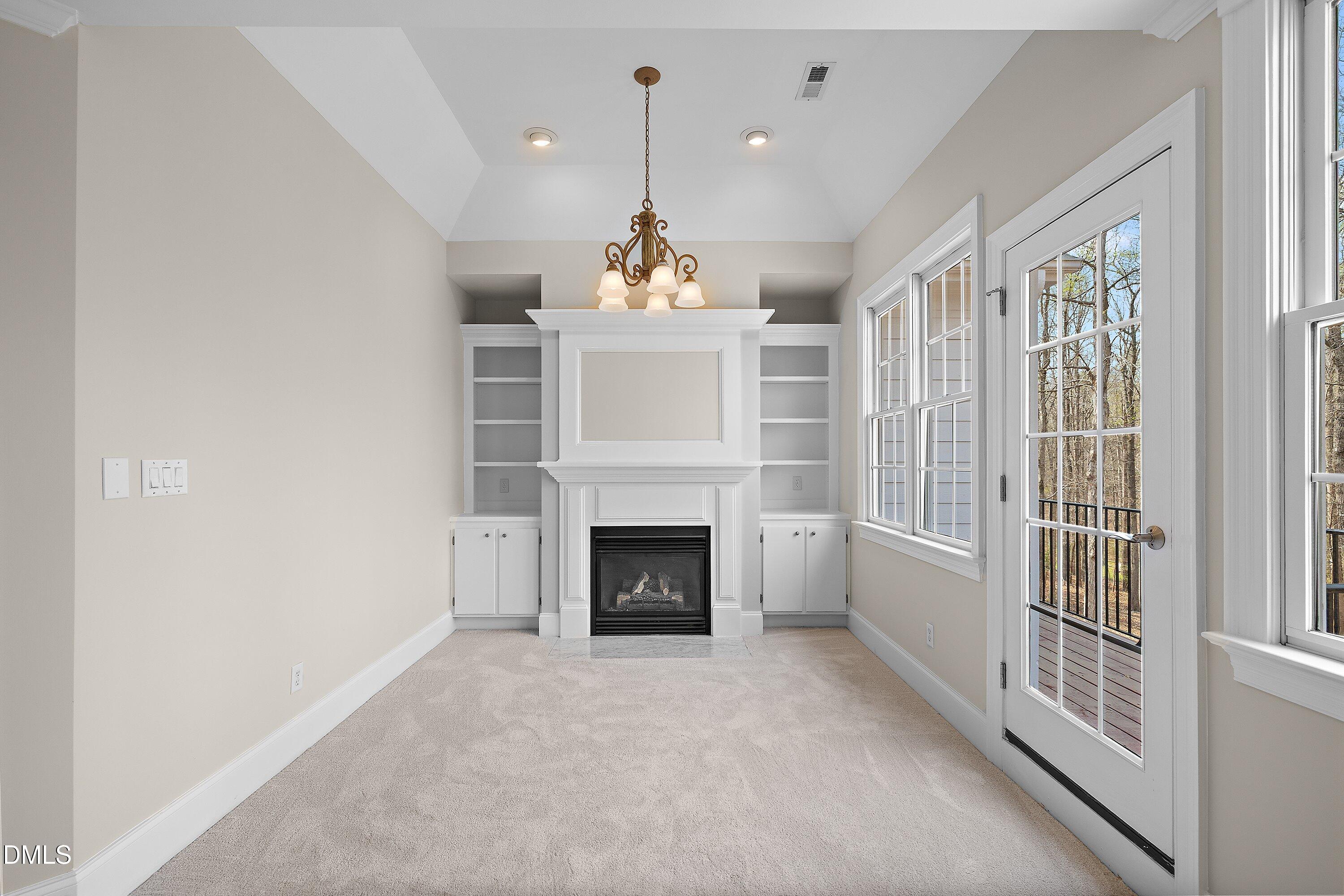 1525 Eglantyne Court Raleigh, NC 27613 - Photo 36 of 105 a living room with furniture a fireplace and a chandelier