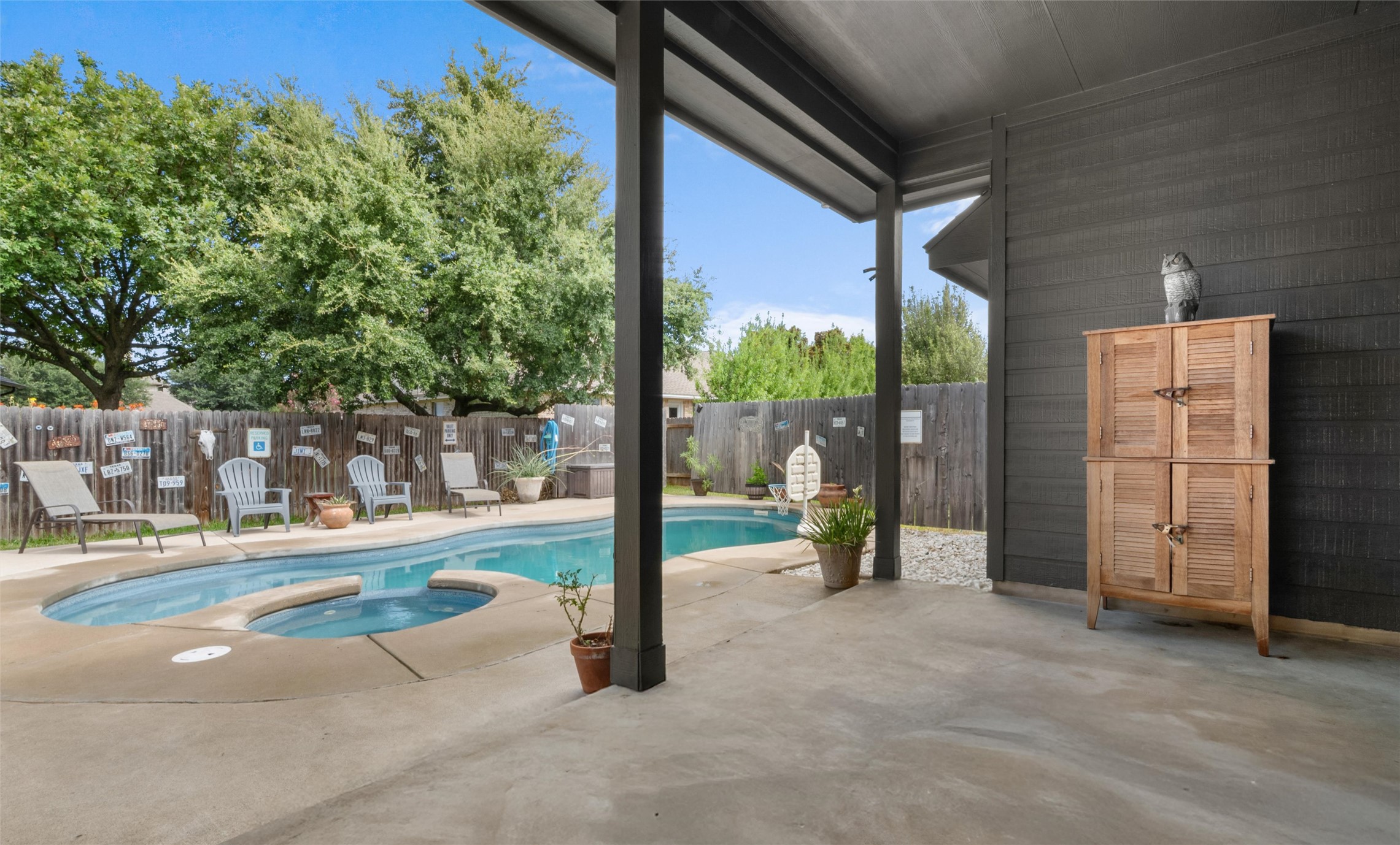 20704 Windmill Ridge Street Pflugerville, TX 78660 - Photo 26 of 34 A private backyard oasis features a freeform pool and spa, alongside a comfortable covered patio.