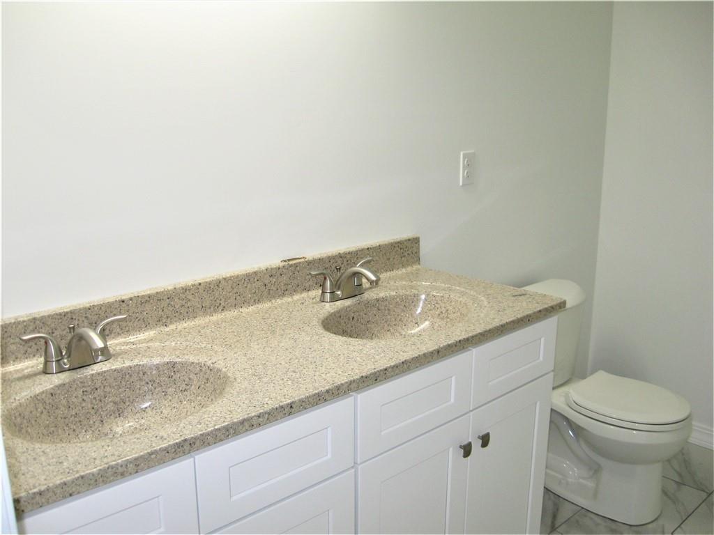 3903 Zimmerly Road Erie, PA 16506 - Photo 16 of 25 a bathroom with a granite countertop sink and a toilet