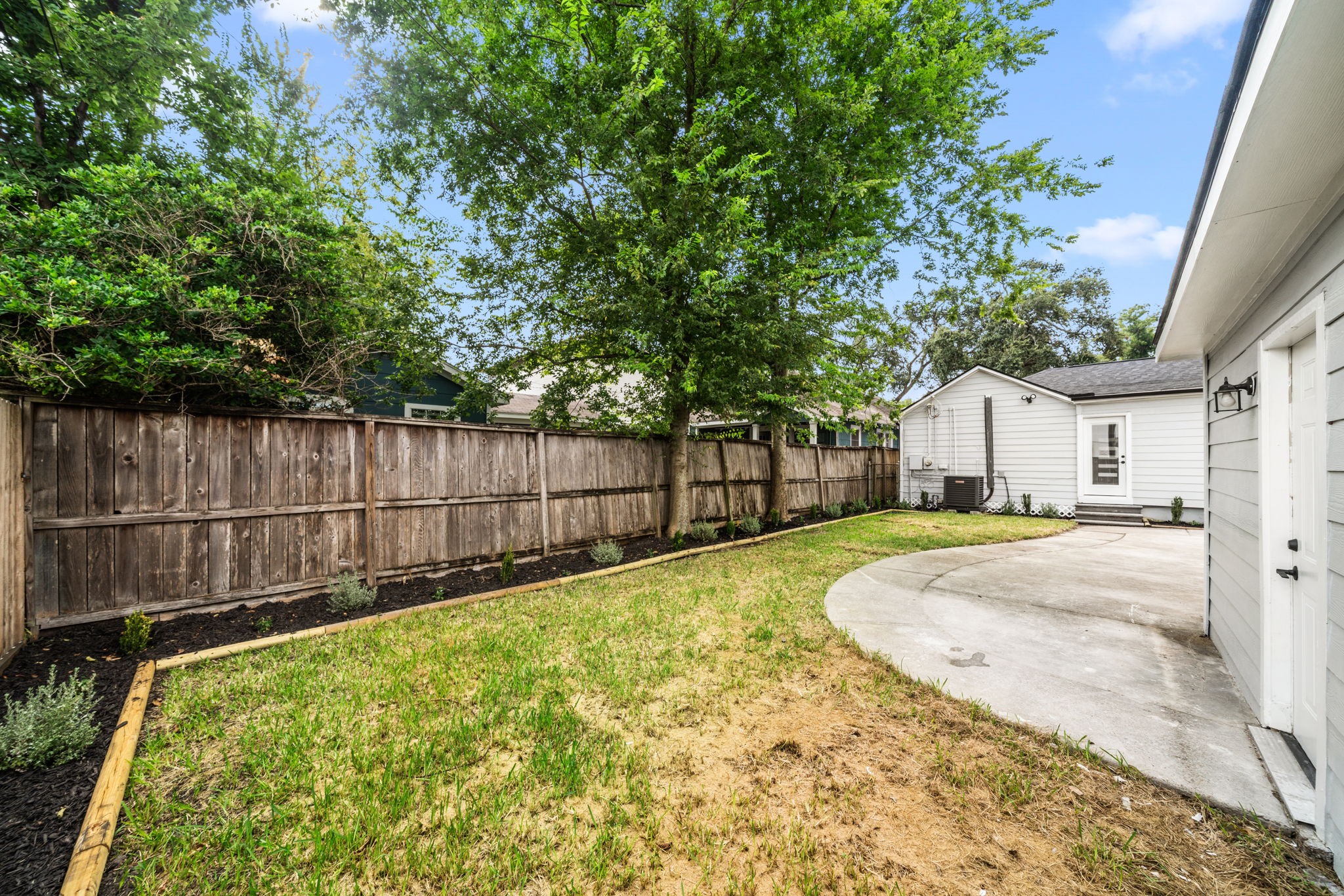 803 East 29th Street Houston, TX 77009 - Photo 27 of 28 a view of a backyard with a large tree and wooden fence