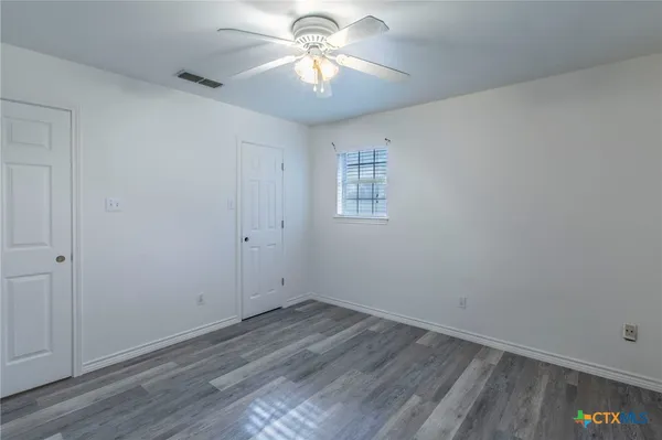 wooden floor in an empty room with a window