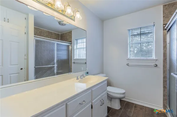 a bathroom with a granite countertop sink toilet and shower