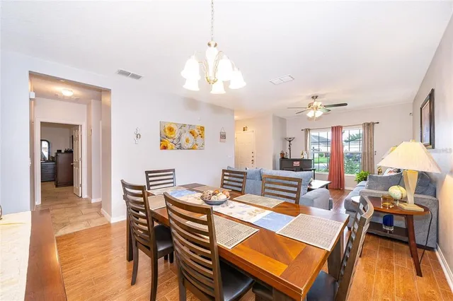 a view of a dining room with furniture a chandelier and wooden floor