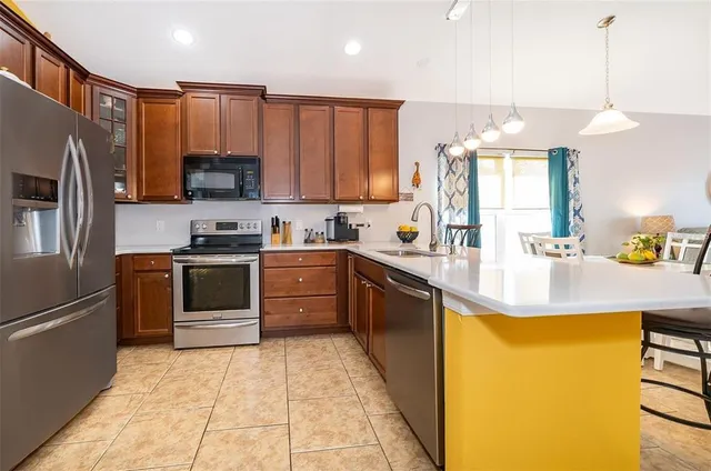 a kitchen with a sink a counter top space stainless steel appliances and cabinets