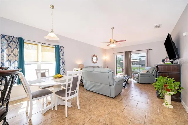 a living room with furniture a flat screen tv and a chandelier