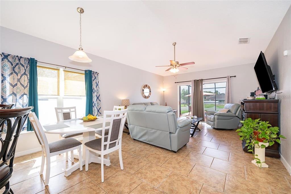 3406 Brant Street St. Cloud, FL 34772 - Photo 16 of 33 a living room with furniture a flat screen tv and a chandelier