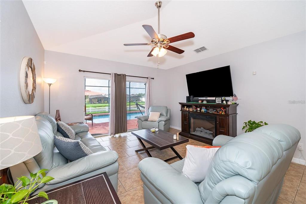 3406 Brant Street St. Cloud, FL 34772 - Photo 19 of 33 a living room with furniture a fireplace and a flat screen tv