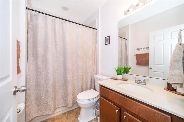 a bathroom with a sink a toilet and shower curtain