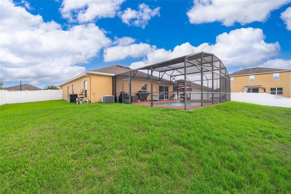 3406 Brant Street St. Cloud, FL 34772 - Photo 32 of 33 a view of a house with a big yard and large trees