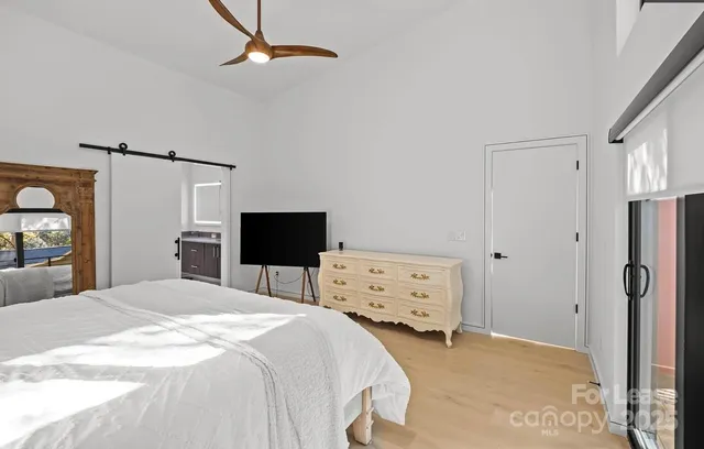 a bedroom with a bed and a flat tv screen on dresser