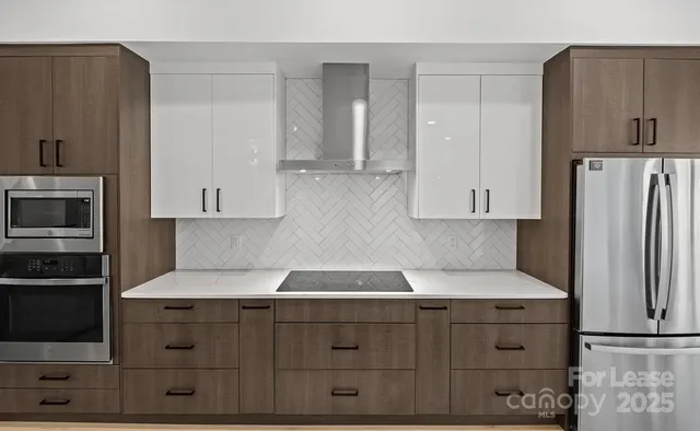 a kitchen with granite countertop white cabinets and stainless steel appliances