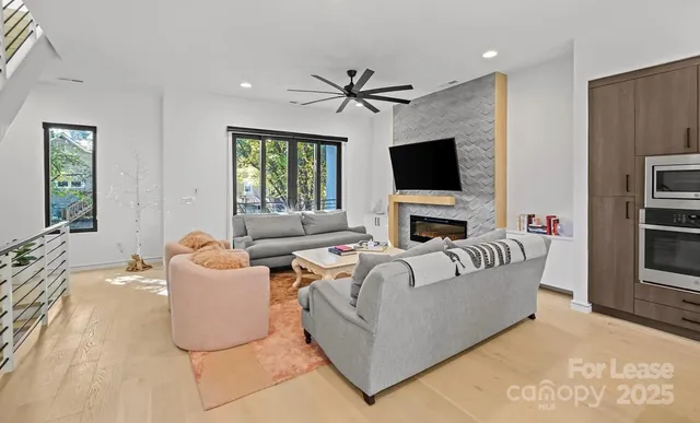 a living room with furniture a fireplace and a flat screen tv